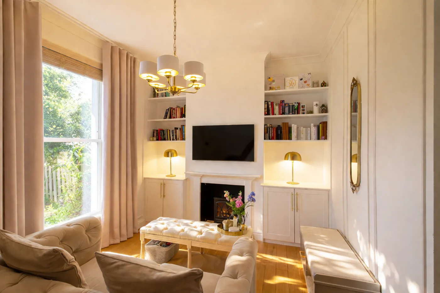 Sitting room with fireplace and fitted shelves in a home marketed by Dwelling & Manor